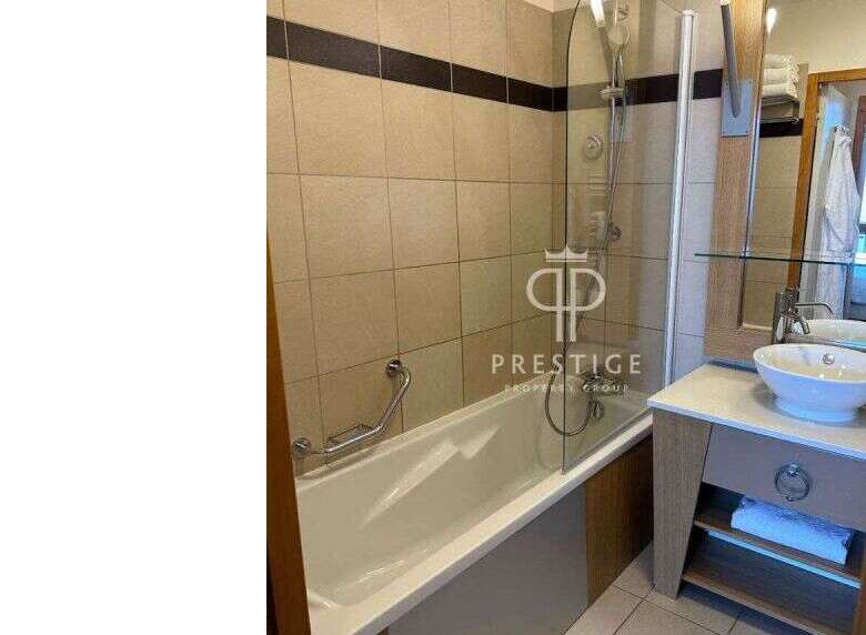 Discover a modern bathroom featuring a sleek bathtub and a stylish glass shower enclosure.