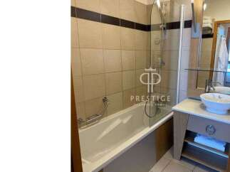 Discover a modern bathroom featuring a sleek bathtub and a stylish glass shower enclosure.