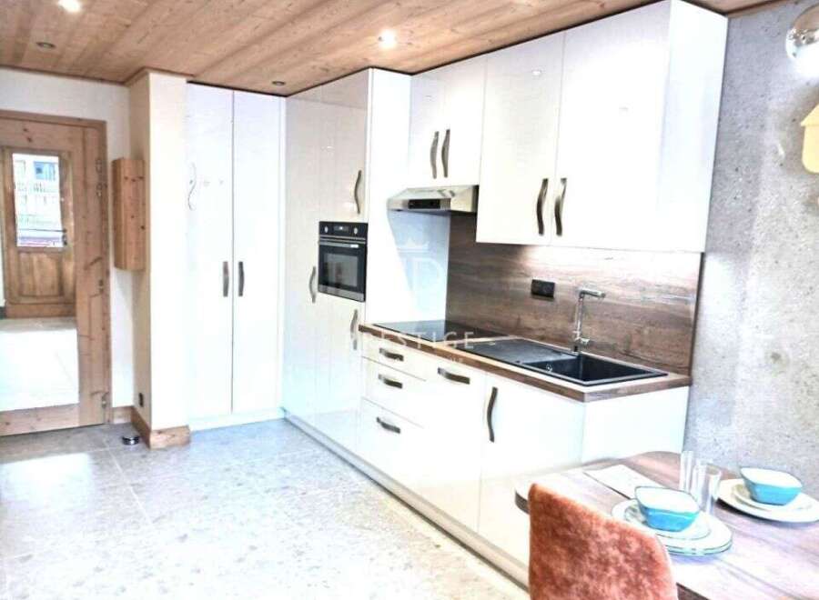 Discover a modern kitchen with sleek white cabinetry and a built-in oven.