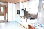 Discover a modern kitchen with sleek white cabinetry and a built-in oven.