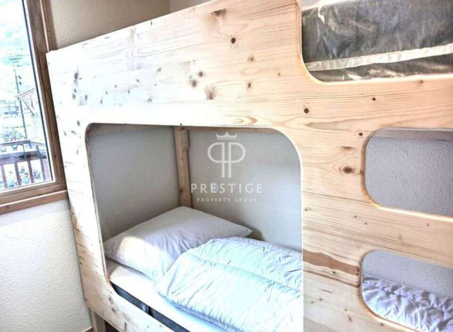 Discover the charm of this cozy bunk bed, perfect for maximizing space in any room.