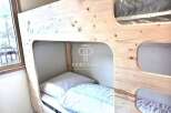 Discover the charm of this cozy bunk bed, perfect for maximizing space in any room.