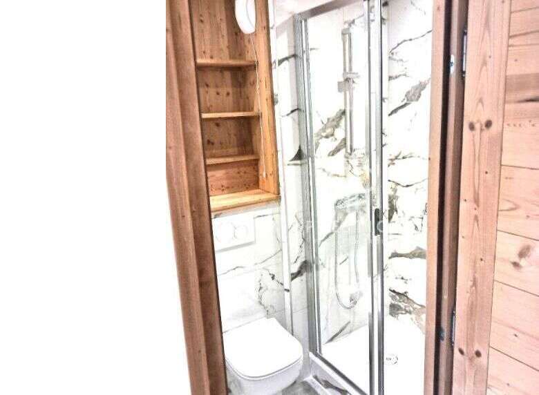 Discover a cozy bathroom with a modern shower and elegant marble-like walls.