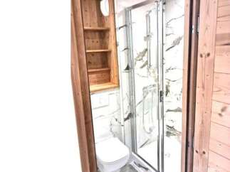 Discover a cozy bathroom with a modern shower and elegant marble-like walls.