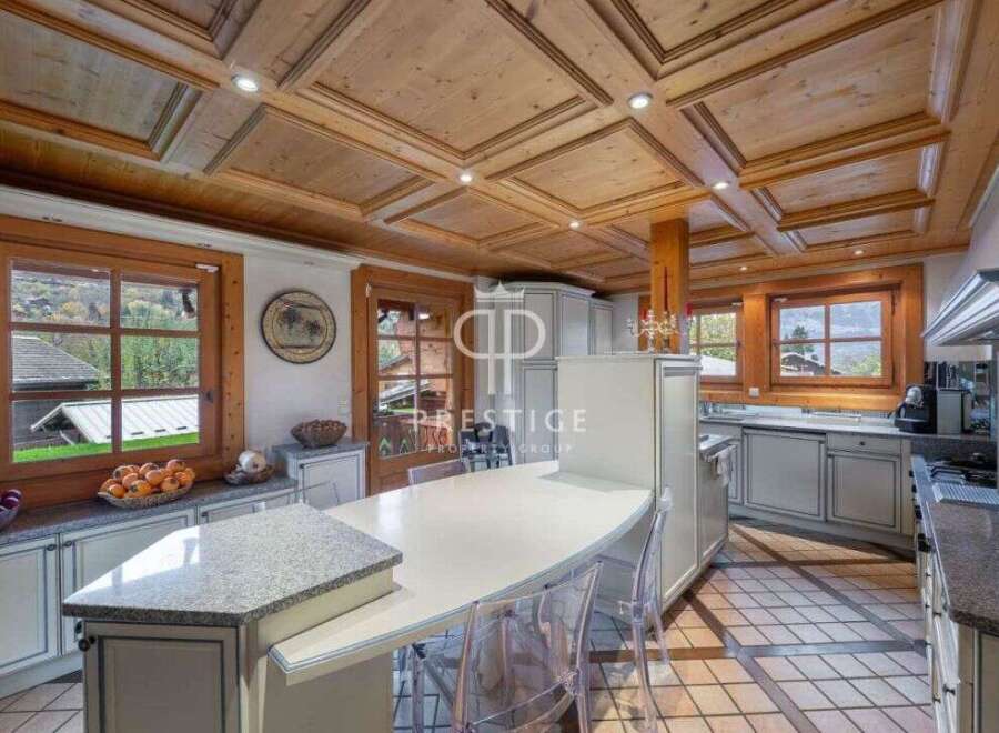 Experience luxury living in this stunning kitchen, featuring exquisite wooden ceiling details and ample natural light.
