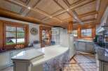 Experience luxury living in this stunning kitchen, featuring exquisite wooden ceiling details and ample natural light.