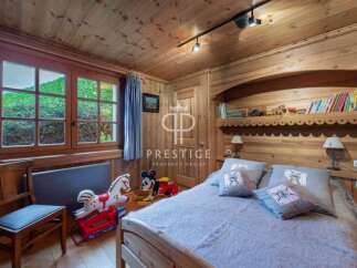 Discover the charm of this cozy bedroom, featuring warm wooden accents and a serene atmosphere.