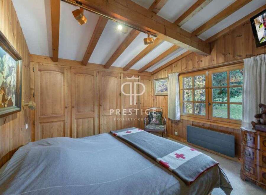 Experience the charm of this cozy bedroom, featuring warm wooden paneling and a rustic aesthetic.