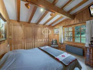Experience the charm of this cozy bedroom, featuring warm wooden paneling and a rustic aesthetic.