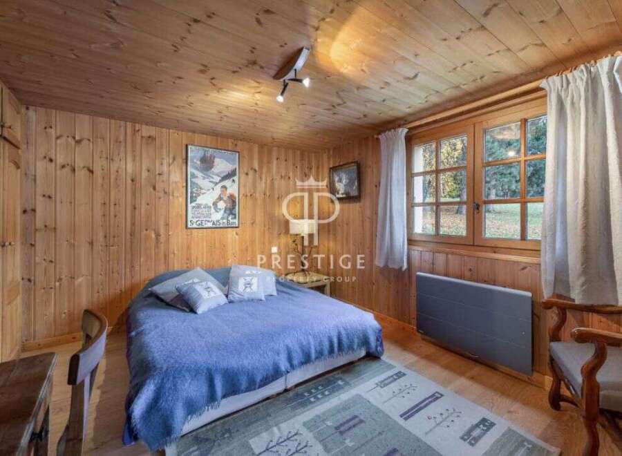 Cozy bedroom with wooden walls and ceiling, creating a warm and inviting atmosphere.