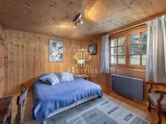 Cozy bedroom with wooden walls and ceiling, creating a warm and inviting atmosphere.