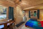 Discover the charm of this cozy cabin retreat, featuring warm wooden interiors and a welcoming atmosphere.