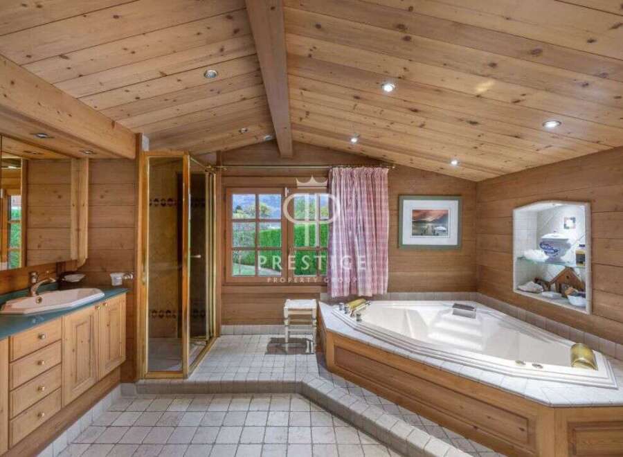 This luxurious bathroom boasts a warm, inviting ambiance with its wooden paneling and vaulted ceiling.