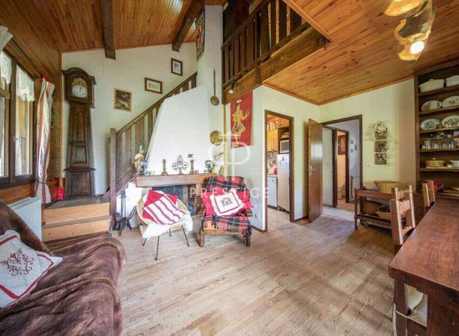 Discover the charm of this cozy home, featuring a warm wooden interior and a welcoming fireplace.