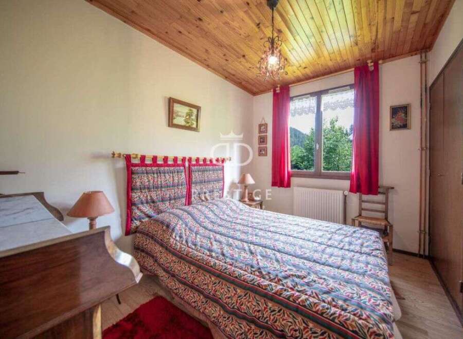 Cozy bedroom with a rustic wooden ceiling and a comfortable bed.
