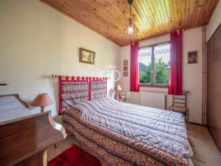 Cozy bedroom with a rustic wooden ceiling and a comfortable bed.