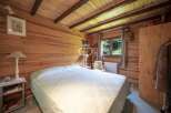 Discover the charm of this cozy bedroom, featuring beautiful wooden walls and ceiling.