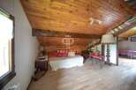 Discover the charm of this unique property, featuring a cozy bedroom with a wooden ceiling and floors.
