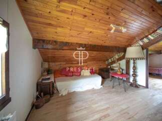 Discover the charm of this unique property, featuring a cozy bedroom with a wooden ceiling and floors.