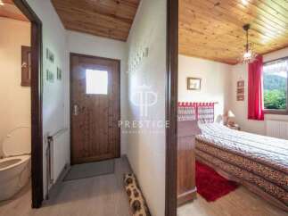 Discover the charm of this cozy property, featuring a warm wooden ceiling and inviting bedroom.
