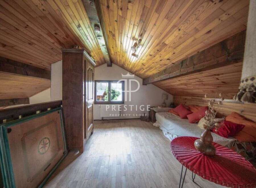 Discover the charm of this cozy attic space, featuring a warm wooden ceiling and flooring.