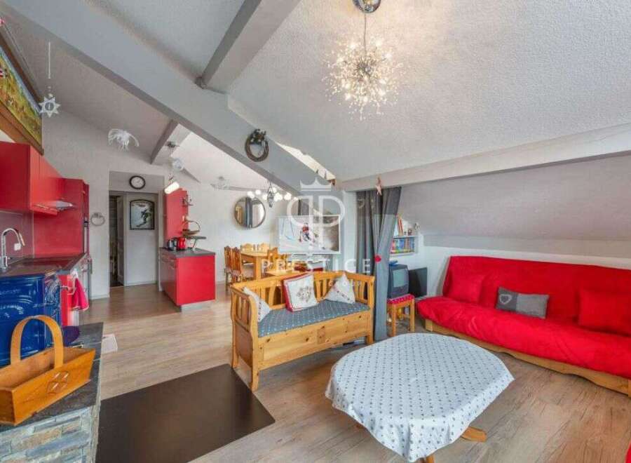 Discover this charming property featuring a cozy living space with a vibrant red sofa and a unique wooden bench.