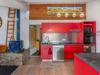 This stunning property boasts a modern kitchen with vibrant red cabinetry, stainless steel appliances, and a sleek countertop.
