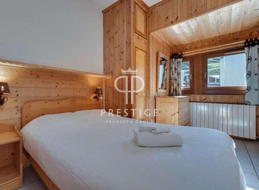 Discover the charm of this cozy bedroom, featuring warm wooden accents and a comfortable bed.
