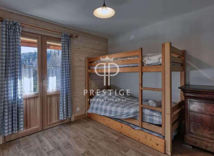 Cozy bedroom featuring a wooden bunk bed, perfect for accommodating guests.