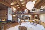 Experience luxury living in this stunning chalet, featuring a warm and inviting interior with exposed wooden beams and walls.