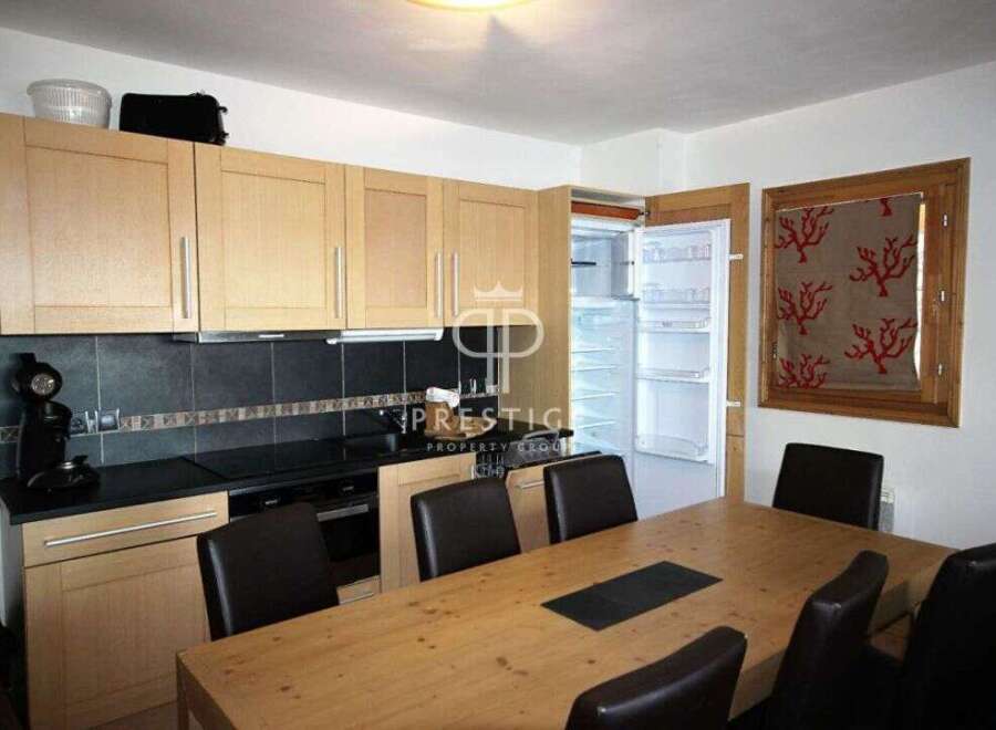 This kitchen features modern cabinetry and appliances, perfect for preparing meals.