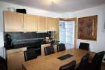 This kitchen features modern cabinetry and appliances, perfect for preparing meals.