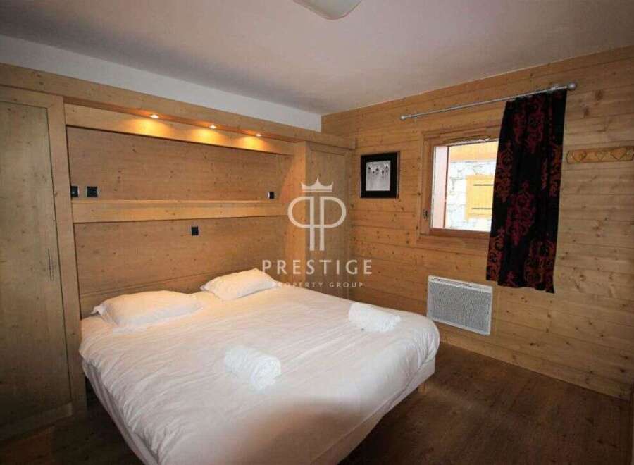 Cozy bedroom with wooden paneling and a comfortable bed.