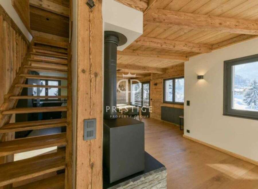 Discover the charm of this stunning property, featuring a beautifully crafted wooden staircase and a cozy fireplace.