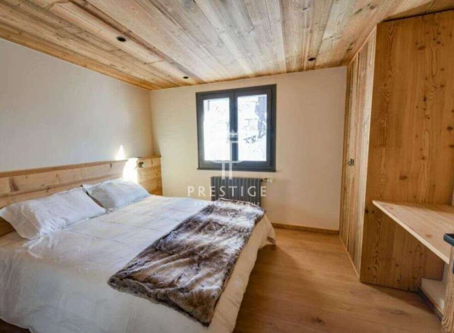 Discover the charm of this cozy bedroom, featuring a warm wooden ceiling and flooring.