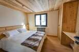 Discover the charm of this cozy bedroom, featuring a warm wooden ceiling and flooring.