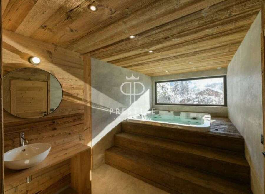 Experience luxury in this stunning bathroom featuring a jacuzzi and a breathtaking view of a snowy landscape.
