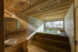 Experience luxury in this stunning bathroom featuring a jacuzzi and a breathtaking view of a snowy landscape.