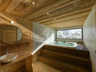 Experience luxury in this stunning bathroom featuring a jacuzzi and a breathtaking view of a snowy landscape.