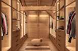 Step into luxury with this stunning walk-in closet, showcasing exquisite wooden craftsmanship and ambient lighting.