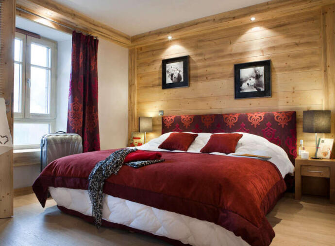 Image of comfortable bed with red bedcover in an alpine lodge
